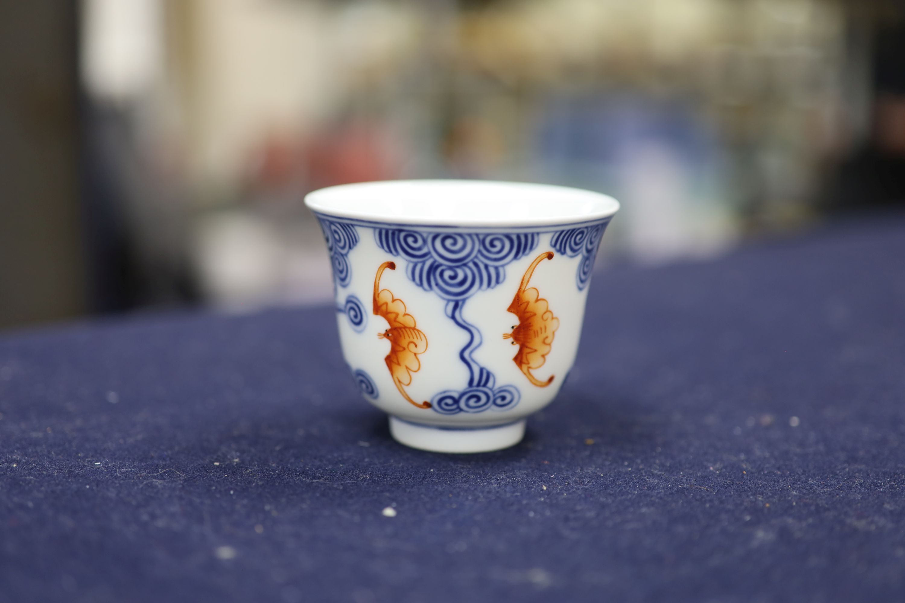 A Chinese underglaze blue and iron red 'bat' cup, height 6cm